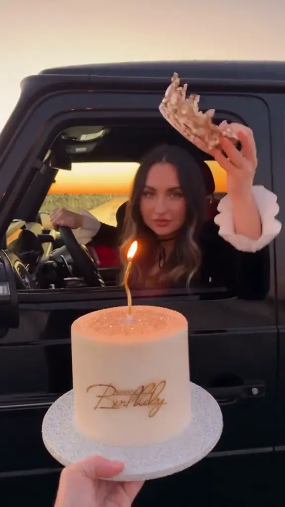 AI birthday video — a crown cake held up to the car window